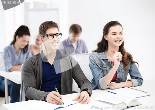 Image of smiling students with notebooks at school