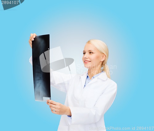 Image of smiling female doctor looking at x-ray