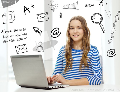 Image of smiling teenage gitl with laptop computer at home