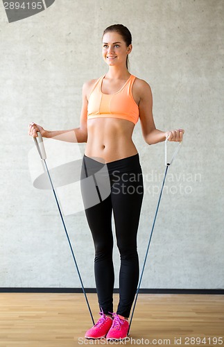 Image of smiling woman with expander in gym