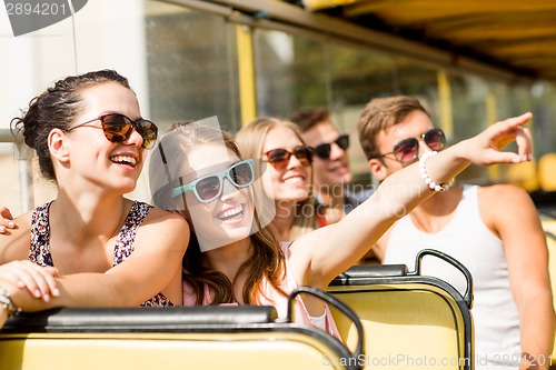 Image of group of smiling friends traveling by tour bus