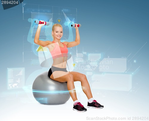 Image of woman with dumbbells sitting on fitness ball