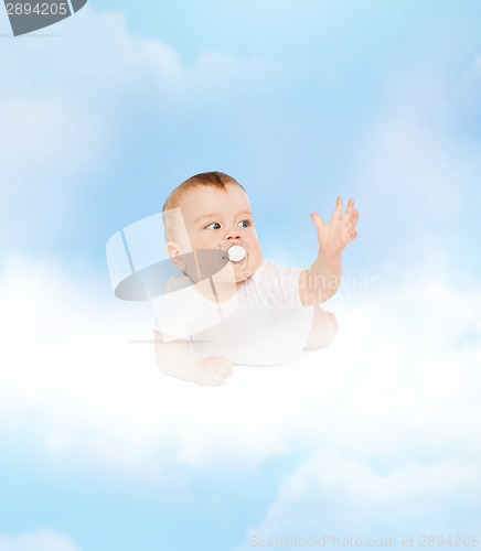 Image of smiling baby lying on cloud with dummy in mouth