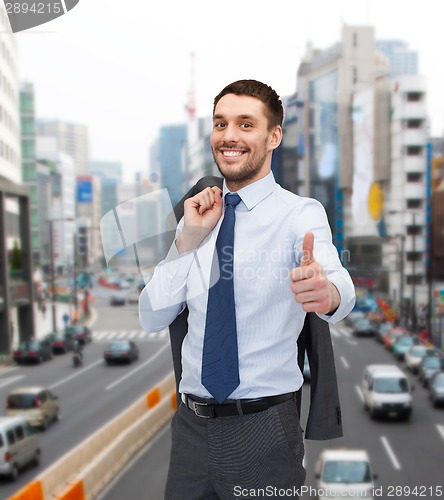 Image of smiling young businessman showing thumbs up