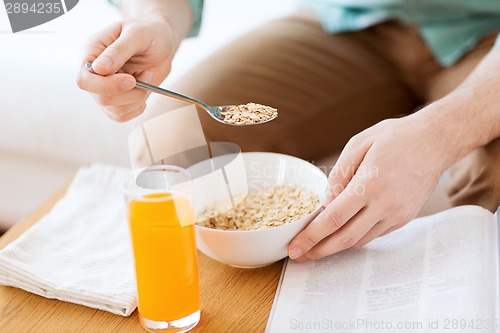 Image of close up of man with magazine eating breakfast