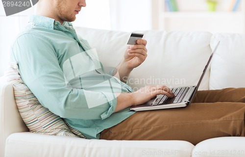 Image of close up of man with laptop and credit card