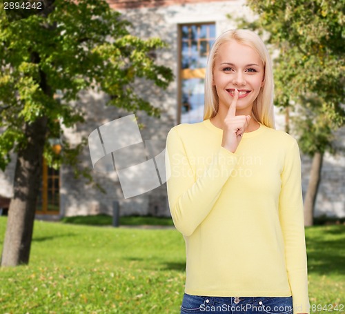 Image of young woman with finger on her lip