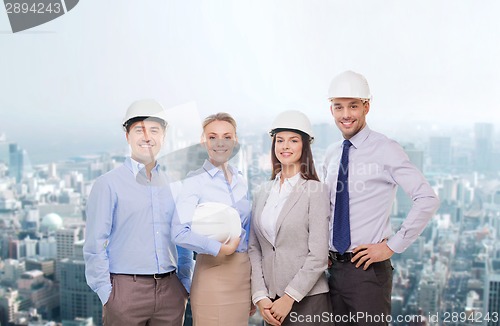 Image of group of smiling businessmen in white helmets