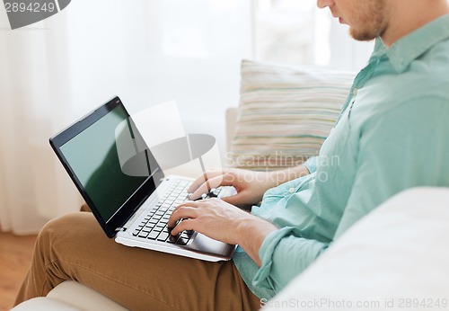 Image of close up of man working with laptop at home