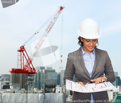 Image of businesswoman in white helmet with blueprint