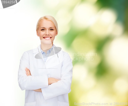 Image of smiling female doctor over natural background