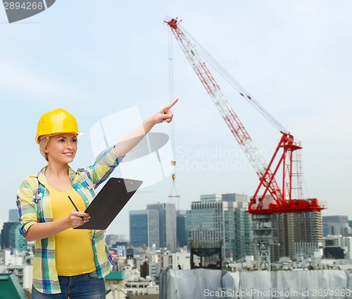 Image of smiling woman in helmet with clipboard