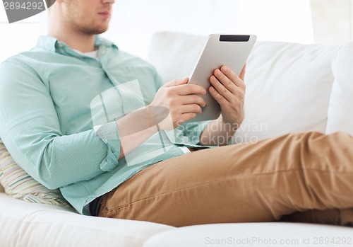 Image of close up of man with tablet pc computer at home