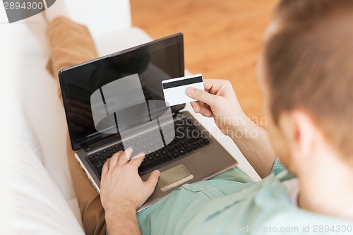 Image of close up of man with laptop and credit card