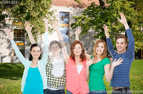 Image of group of smiling students waving hands