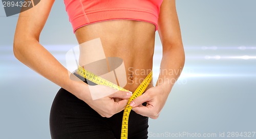 Image of close up of female hands measuring waist