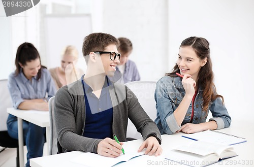 Image of smiling students with notebooks at school