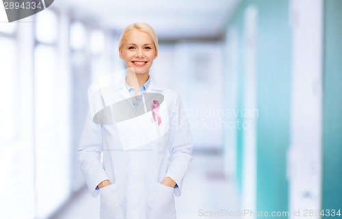 Image of smiling female doctor with cancer awareness ribbon