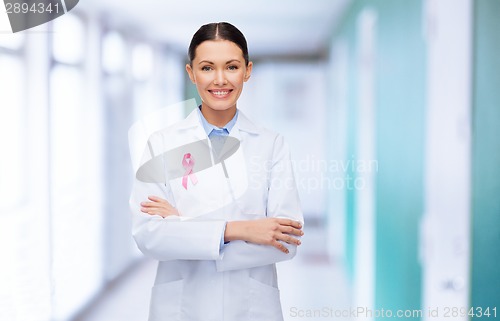 Image of smiling female doctor with cancer awareness ribbon
