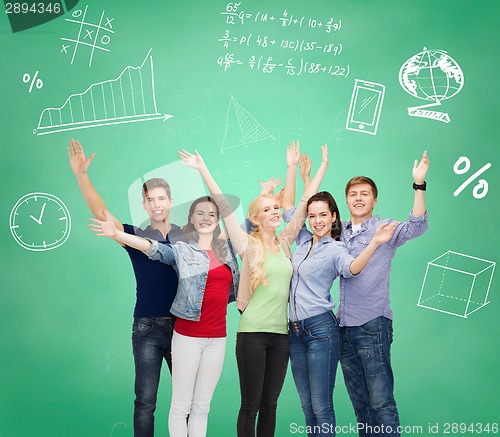 Image of group of smiling students over green board