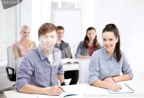 Image of smiling students with notebooks at school