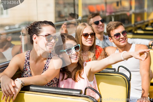 Image of group of smiling friends traveling by tour bus
