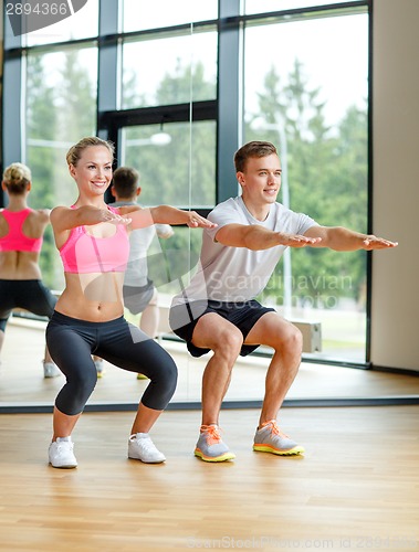 Image of smiling man and woman in gym