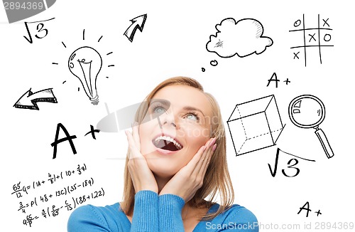 Image of amazed young woman looking up