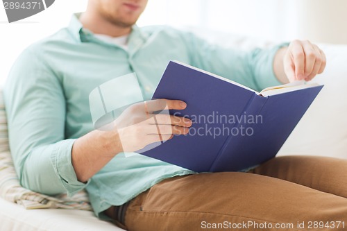 Image of close up of man reading book at home