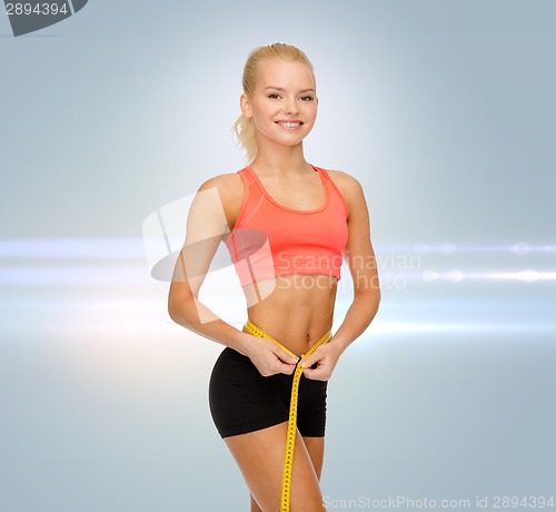 Image of smiling sporty woman with measuring tape