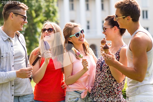 Image of group of smiling friends with ice cream outdoors