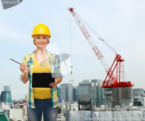 Image of smiling woman in helmet with clipboard