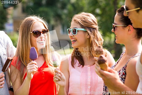 Image of group of smiling friends with ice cream outdoors