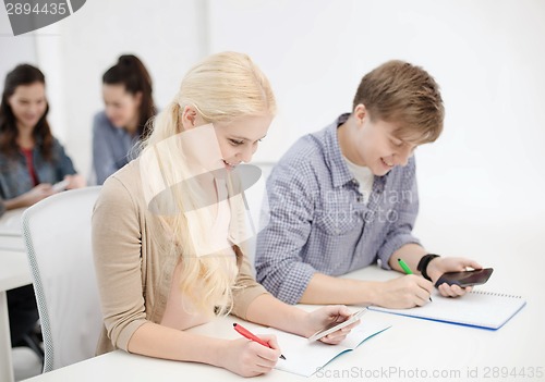 Image of smiling students with notebooks at school