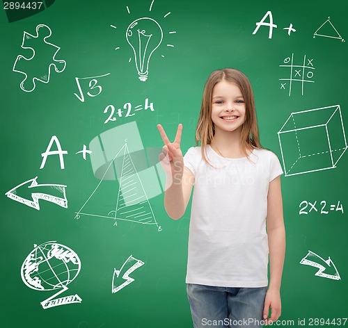 Image of smiling little girl in white showing victory sign