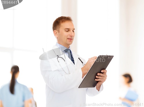 Image of smiling male doctor with clipboard and stethoscope