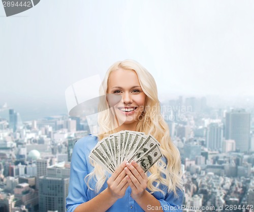 Image of smiling young woman with us dollar money