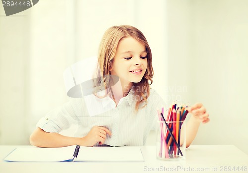 Image of girl drawing with pencils at school