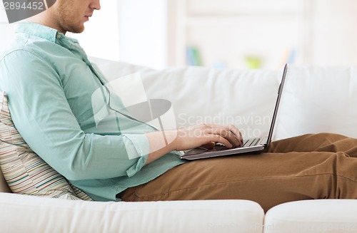 Image of close up of man working with laptop at home