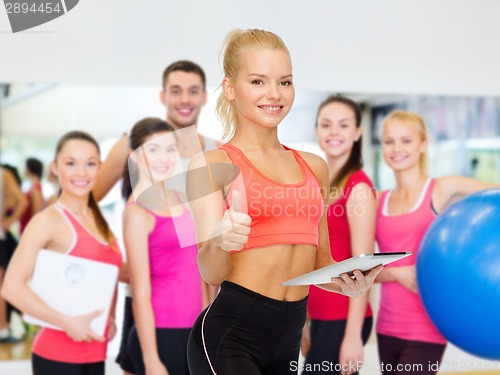 Image of smiling sporty woman with tablet pc computer