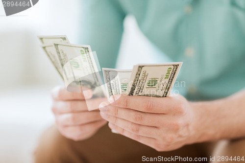 Image of close up of man counting money at home