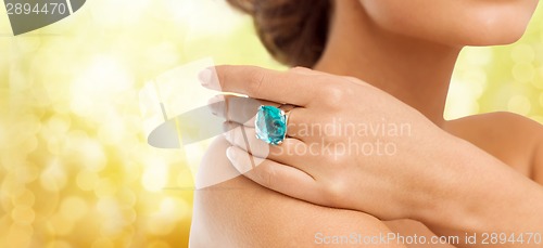 Image of closeup of woman hand with big blue cocktail ring