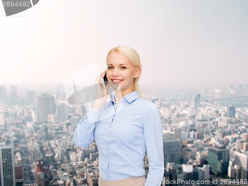 Image of young smiling businesswoman with smartphone