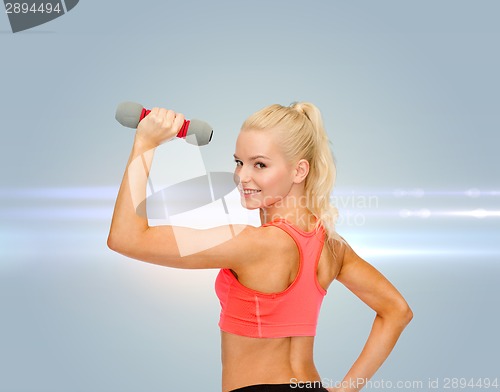 Image of young sporty woman with light dumbbell