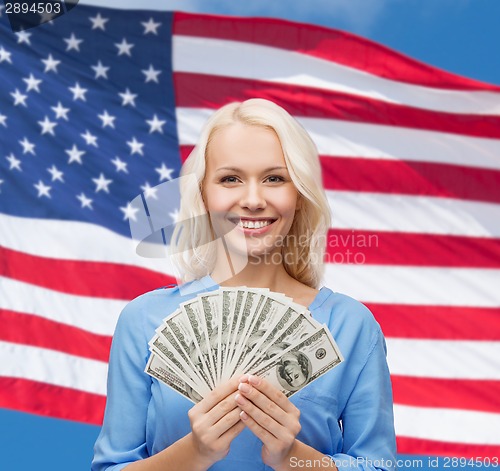 Image of smiling young woman with us dollar money