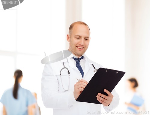 Image of smiling male doctor with clipboard and stethoscope