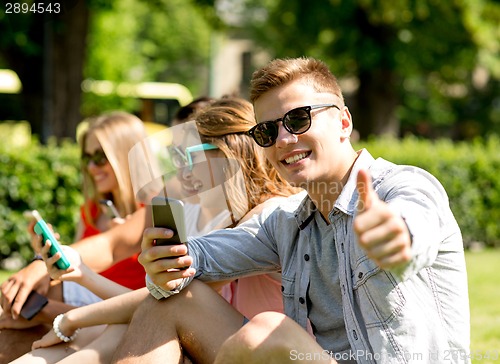 Image of smiling man with smartphone showing thumbs up