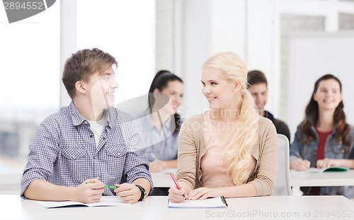 Image of two teenagers with notebooks at school