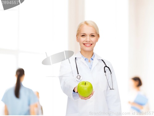 Image of smiling female doctor with green apple