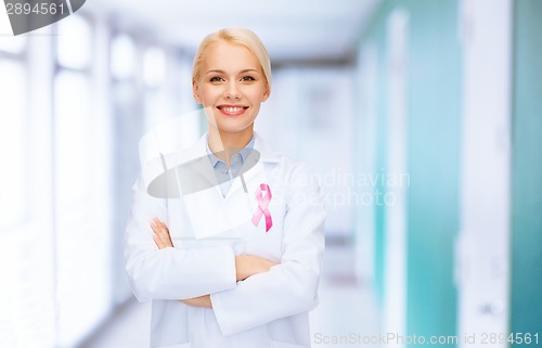 Image of smiling female doctor with cancer awareness ribbon